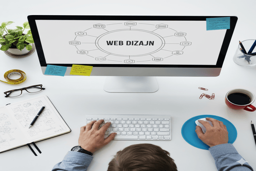 Osoba leđima okrenuta sjedi za stolom u svijetlom i modernom uredu. Veliki monitor ispred nje prikazuje istaknuti natpis 'WEB DIZAJN'.