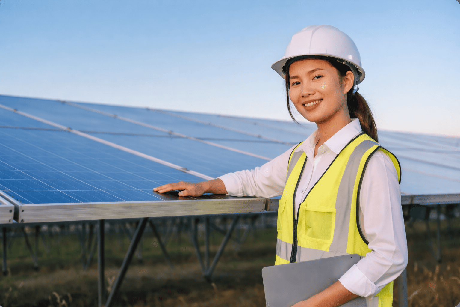 Monterica solarnih fotonaponskih sustava u bijeloj košulji stoji uz solarne panele na solarnoj elektrani.